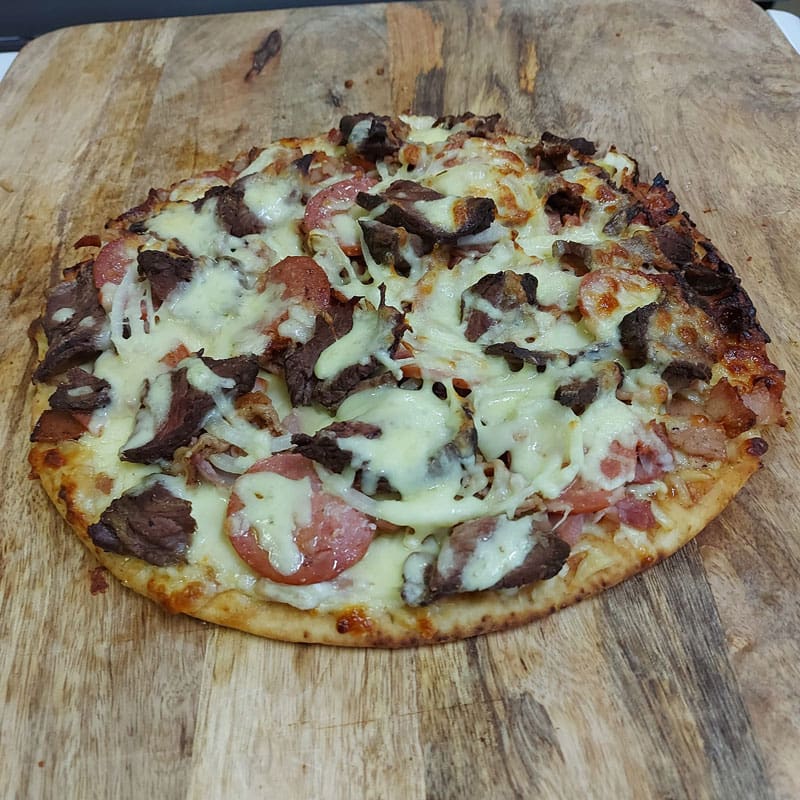 meat lovers pizza on wooden board